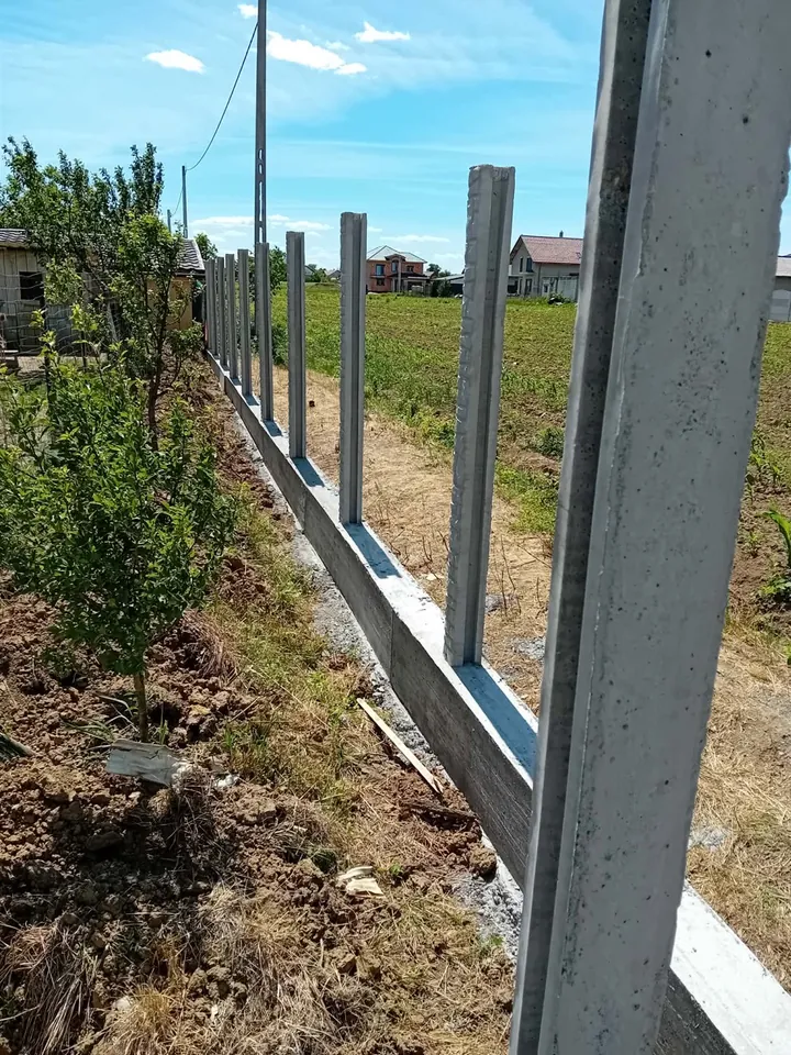 Șir de stâlpi din beton montați și aliniați pe o fundație continuă